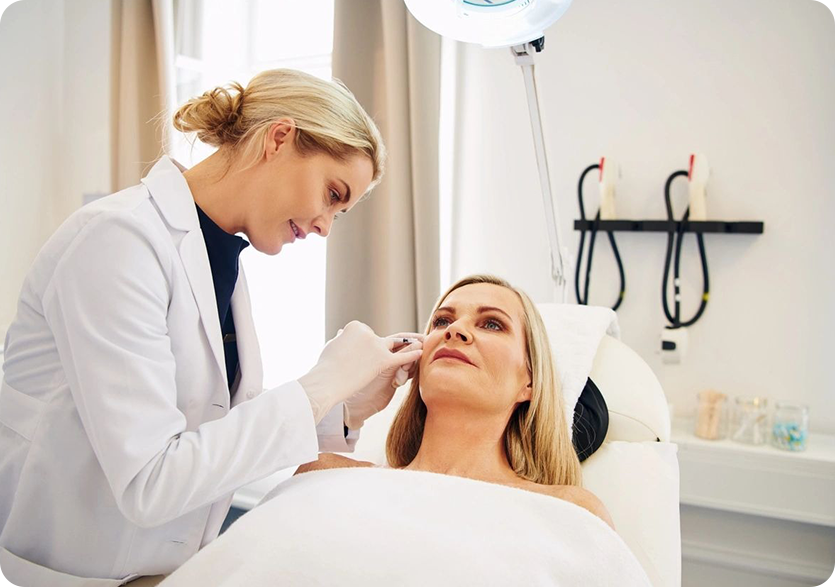 A woman is getting her face waxed by a doctor.