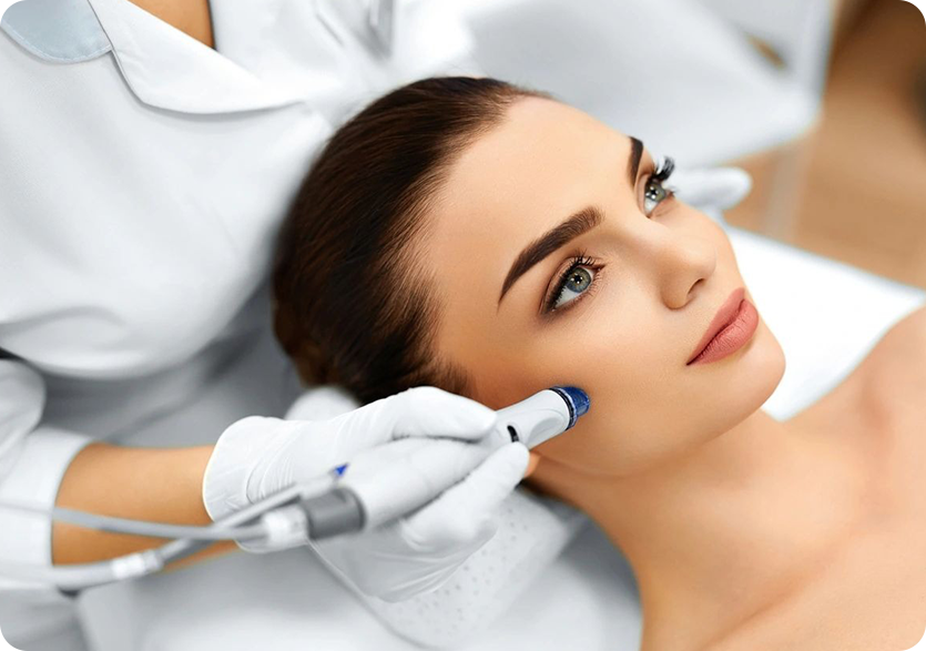 A woman getting her face cleaned by an esthetician.