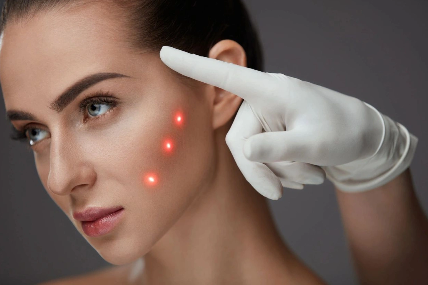 A woman with red spots on her face and hands touching it.