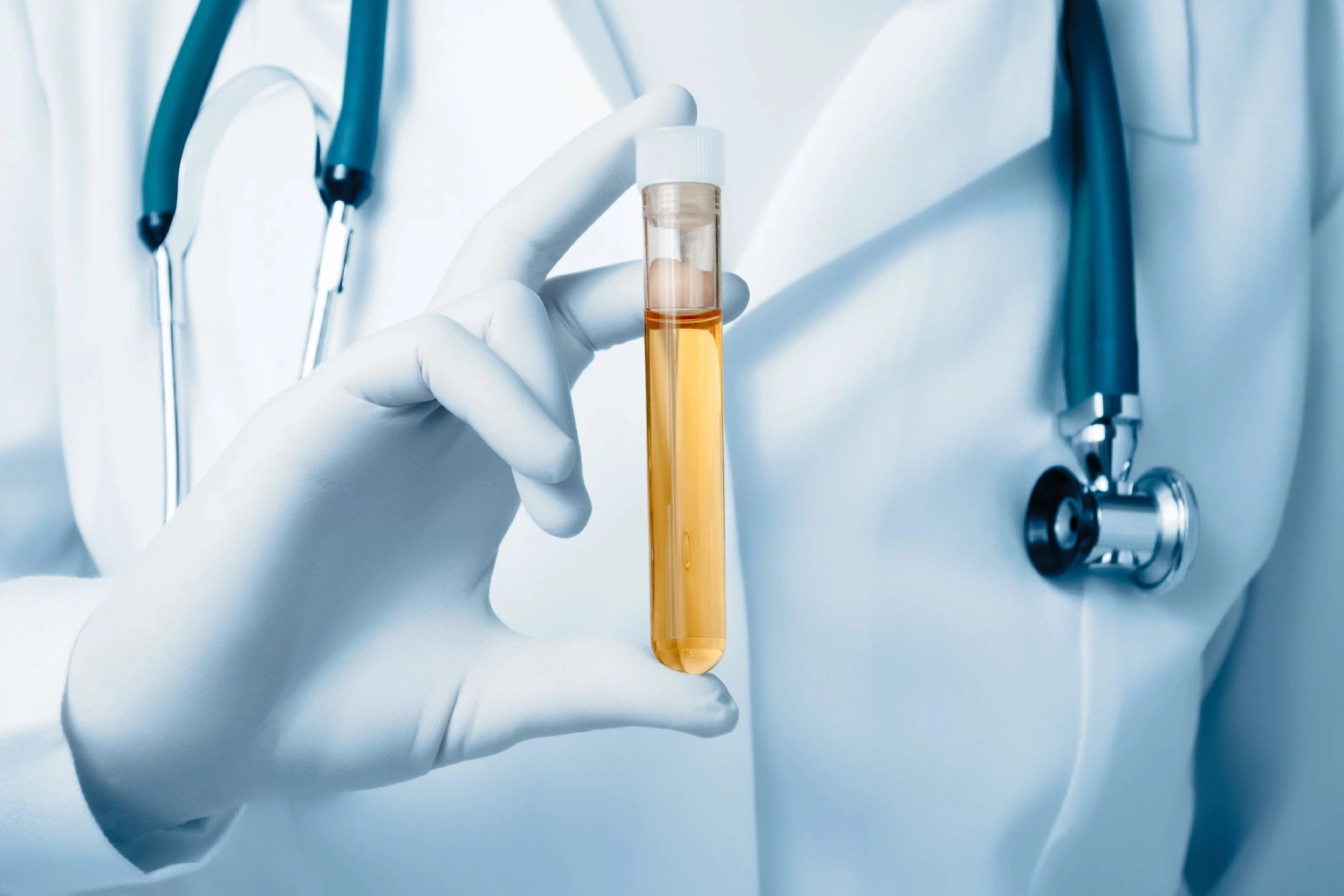 A doctor holding an orange tube of liquid.